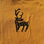 Black deer silhouette on a mustard yellow fabric background