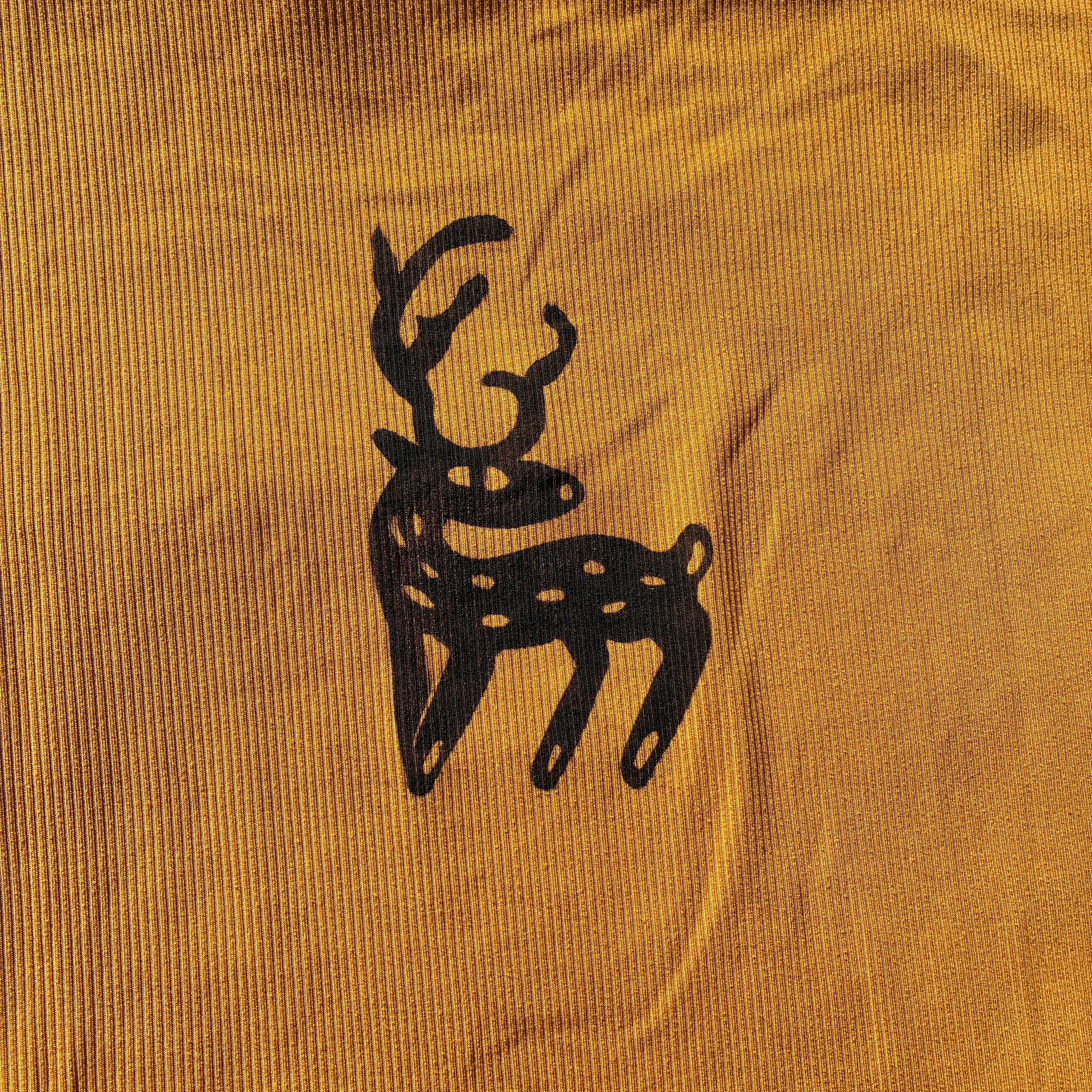 Black deer silhouette on a mustard yellow fabric background